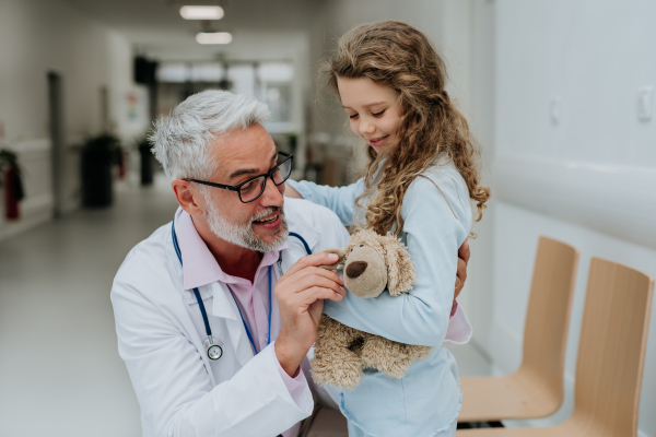 Doctor playing with his little patient at pediatrics.