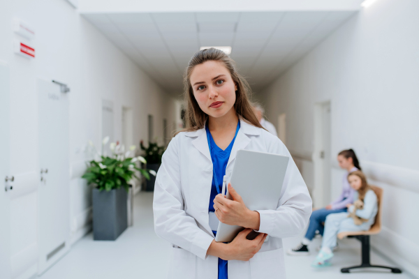 Portrait of young woman doctor at a hospital corridor.