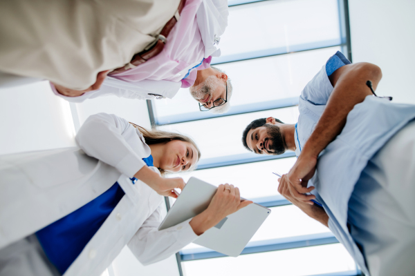 Team of doctors meeting at a hospital corridor, low angle view.