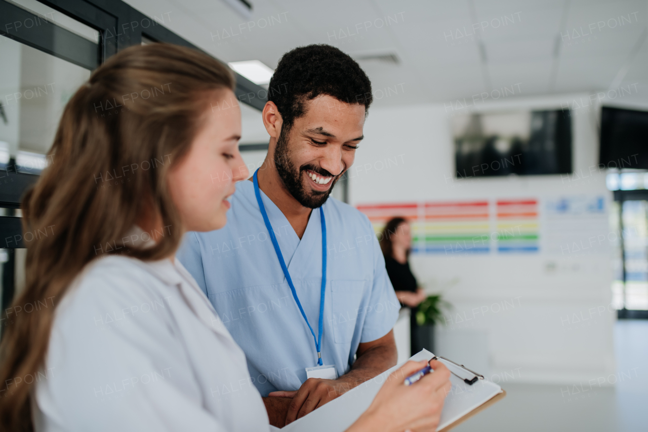 Young doctors, colleagues, talking and discussing at hospital corridor. Health care concept.