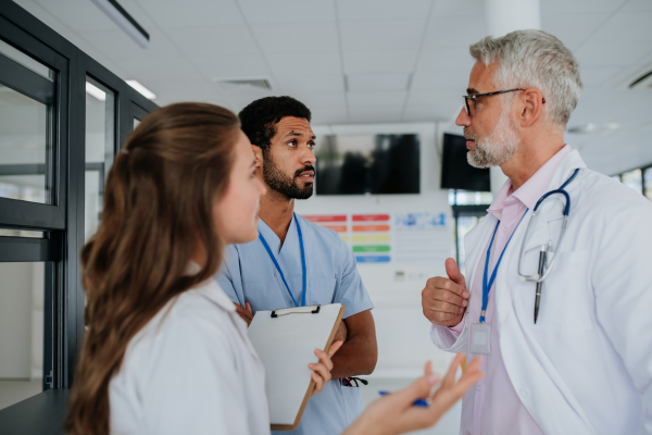 Team of doctors discussing something at a hospital corridor.