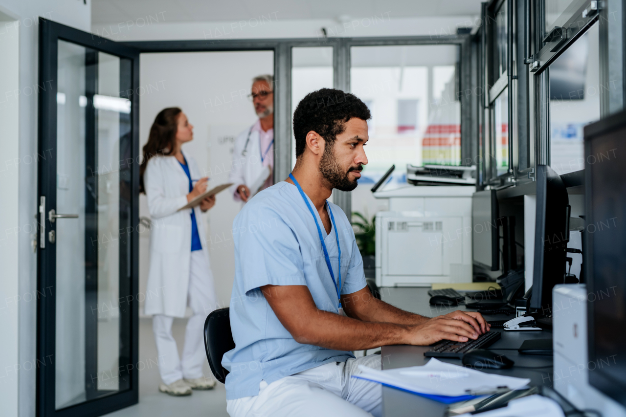 Young doctor working on computer in the hospital office.