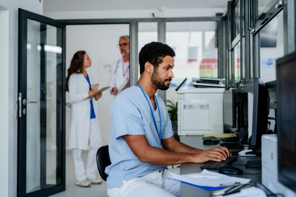 Young doctor working on computer in the hospital office.