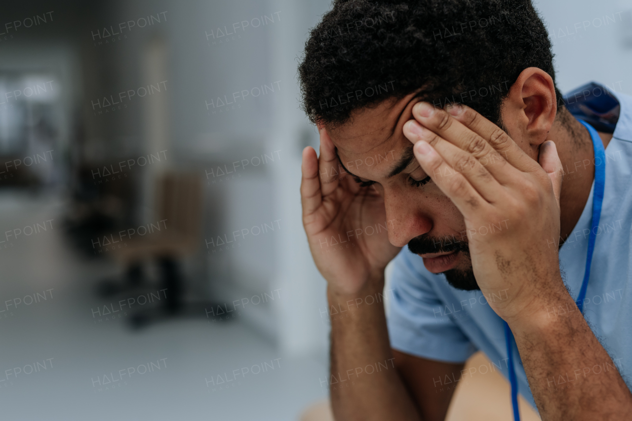 Close-up of tired doctor, sitting at a hospital corridor.