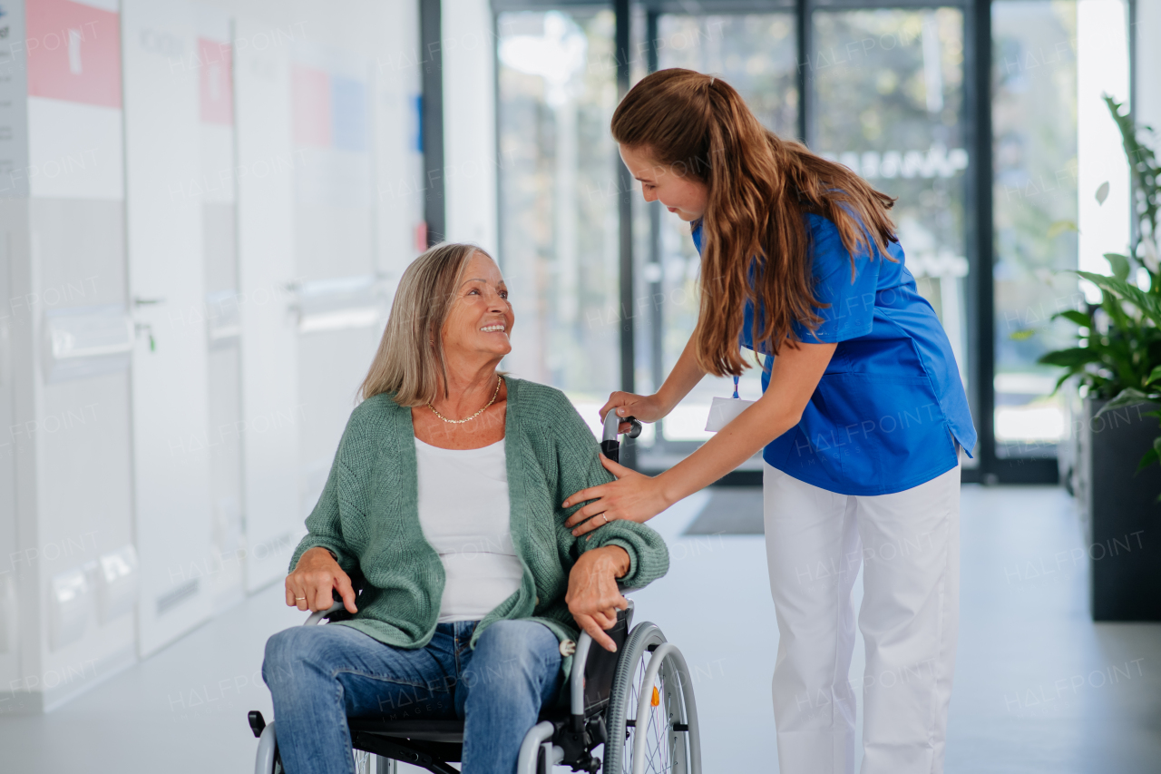 Young woman doctor taking care of senior woman at a wheelchair.