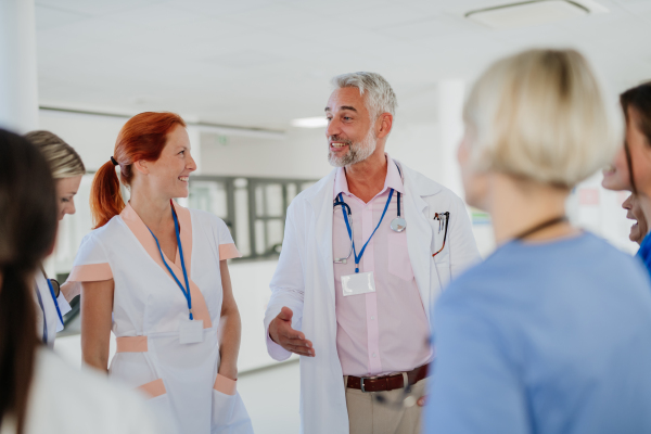 Team of doctors discussing something at a hospital corridor.