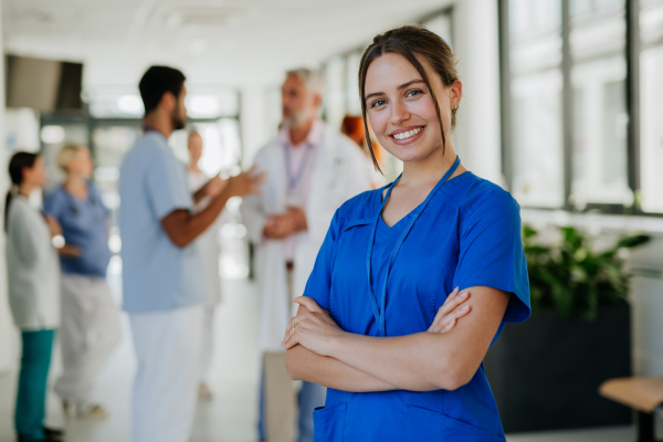 Portrait of young woman nurse at a hospital corridor.