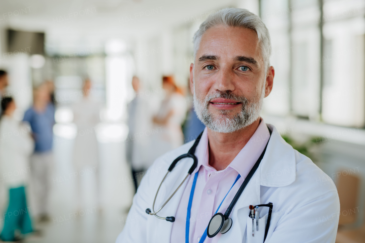 Portrait of mature doctor at a hospital corridor.