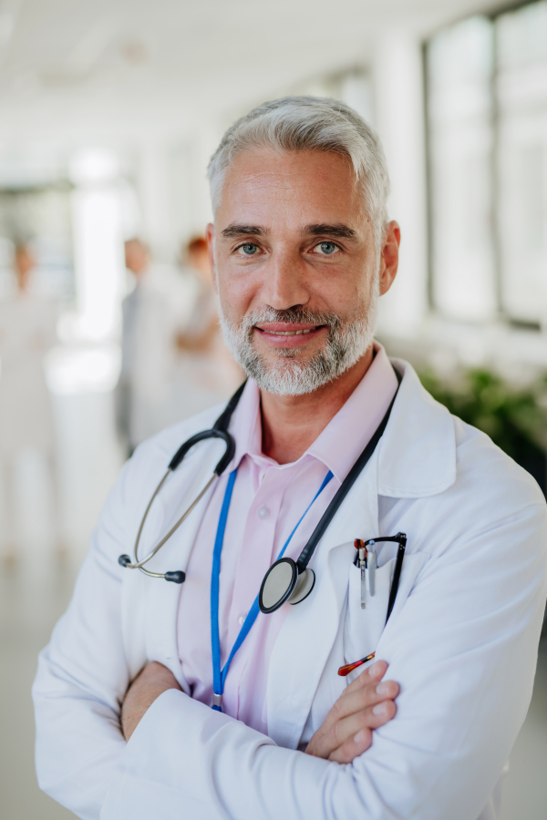 Portrait of mature doctor at a hospital corridor.