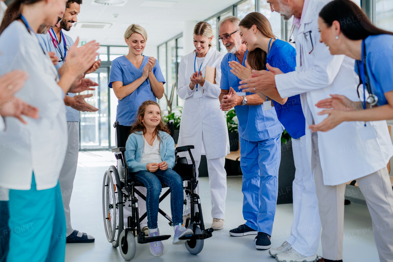 Medical staff clapping to patient who recovered from a serious illness.