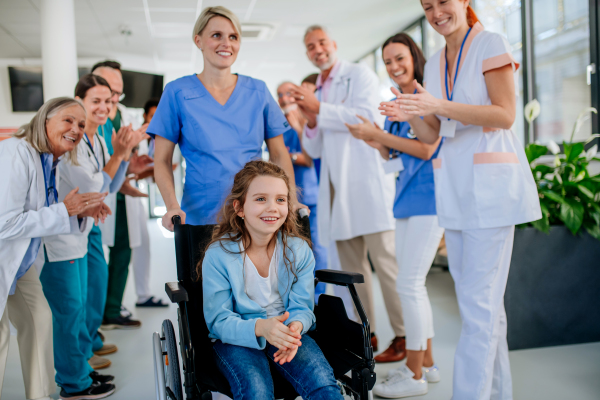 Medical staff clapping to patient who recovered from a serious illness.