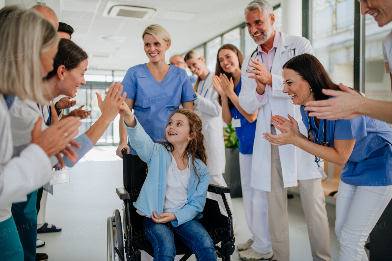 Medical staff clapping to patient who recovered from a serious illness.