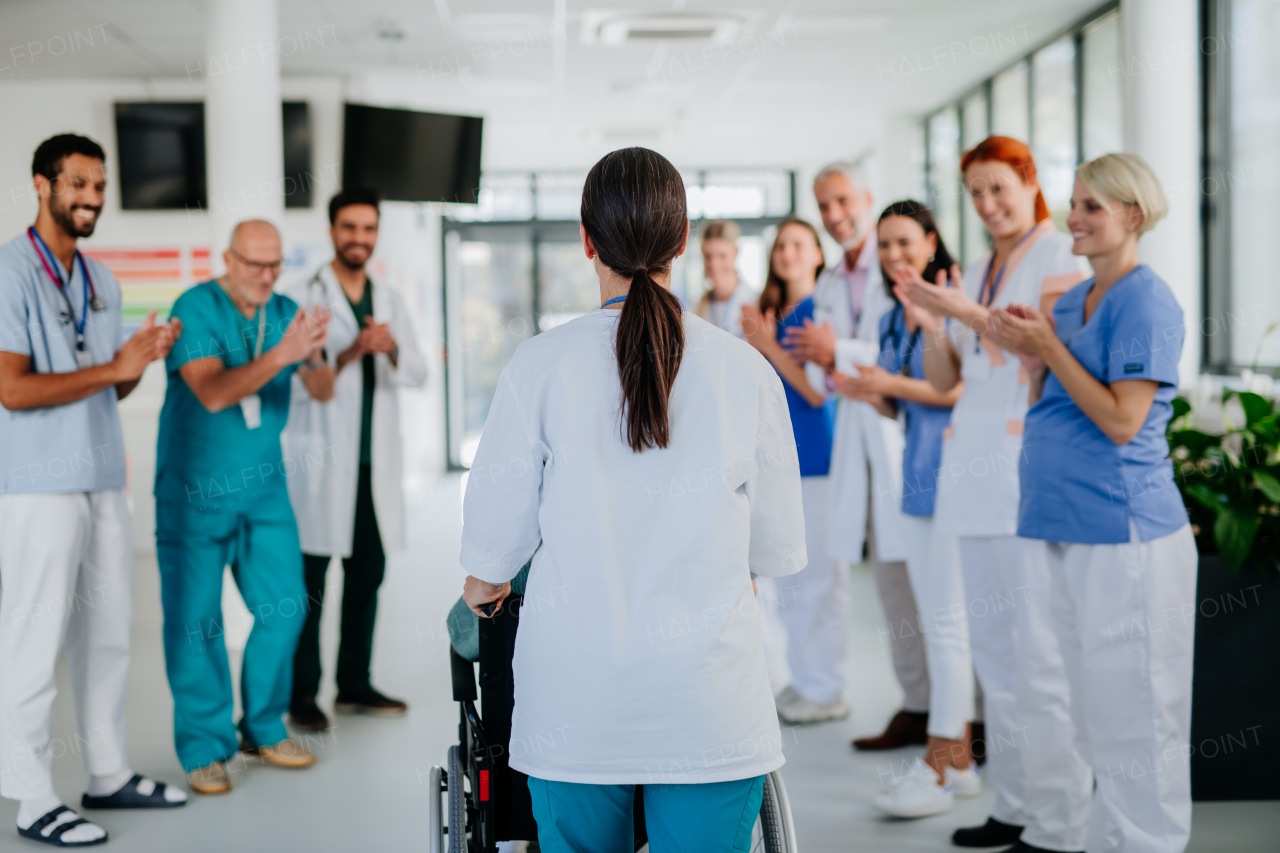 Medical staff clapping to patient who recovered from a serious illness.