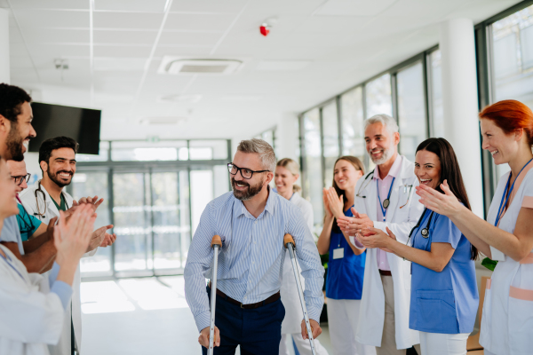 Medical staff clapping to patient who recovered from a serious accident.