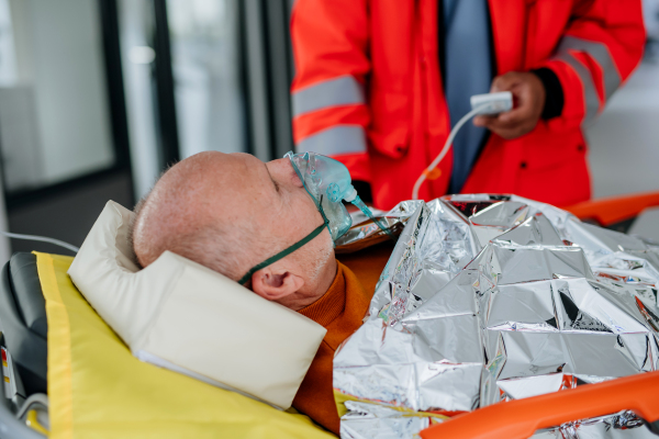 Rescuers taking care of patient from an ambulance.