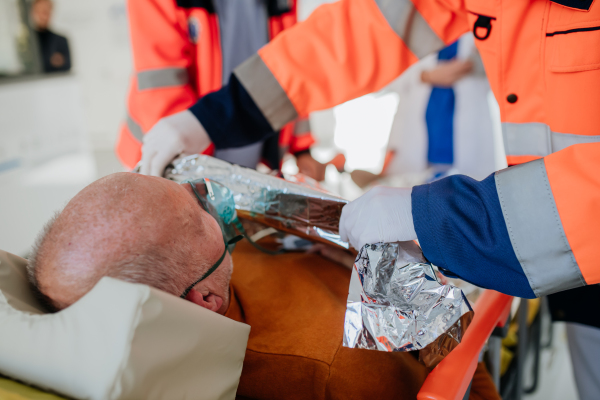 Rescuers taking care of patient from an ambulance, close-up.