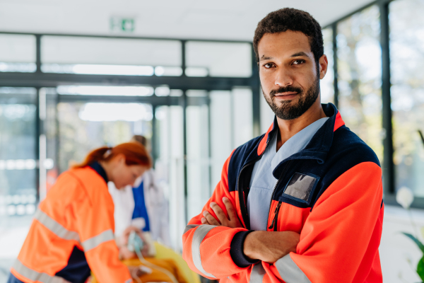 Portrait of rescuer man, his colleagues taking care of patient from ambulance.