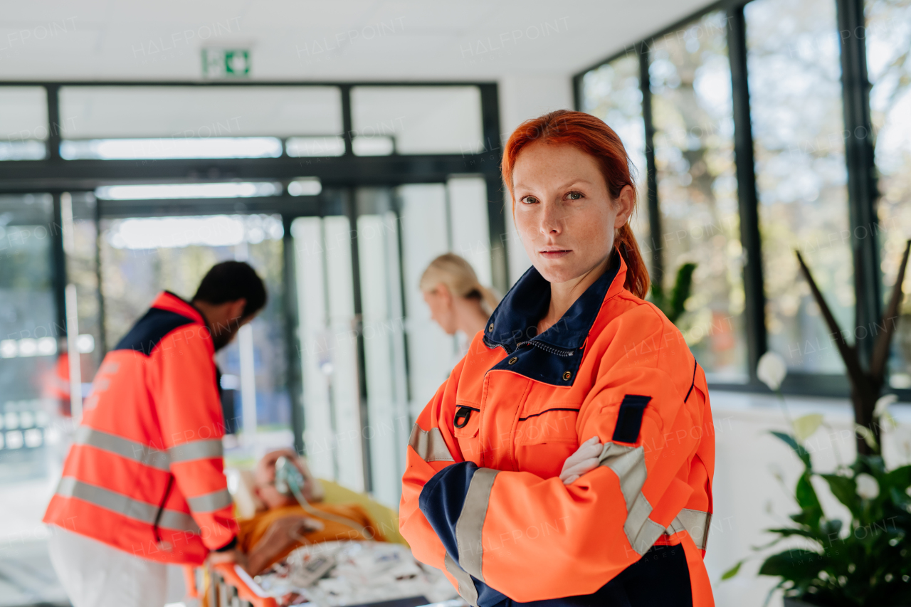 Portrait of rescuer woman, her colleagues taking care of patient from an ambulance.