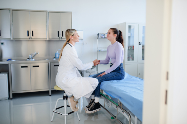 Young woman doctor examining teenage girl in the ambulance.