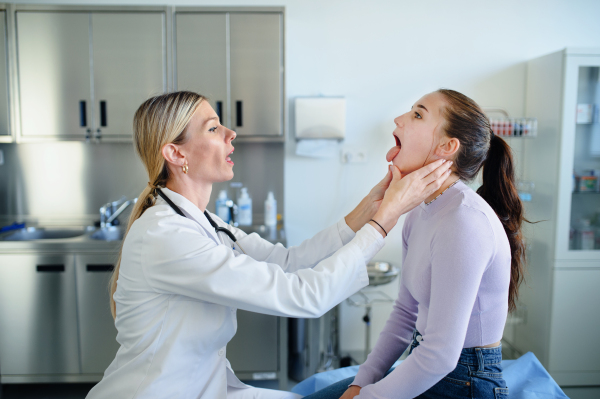 Young woman doctor examining teenage girl in the ambulance.