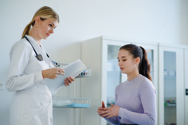 Young woman doctor examining teenage girl in the ambulance.