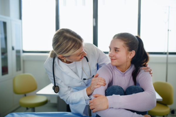 Close-up of doctor consoling teenage girl in the ambulance office.