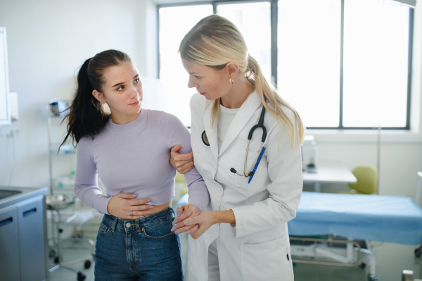 Close-up of doctor helping sick teenage girl in the ambulance office.