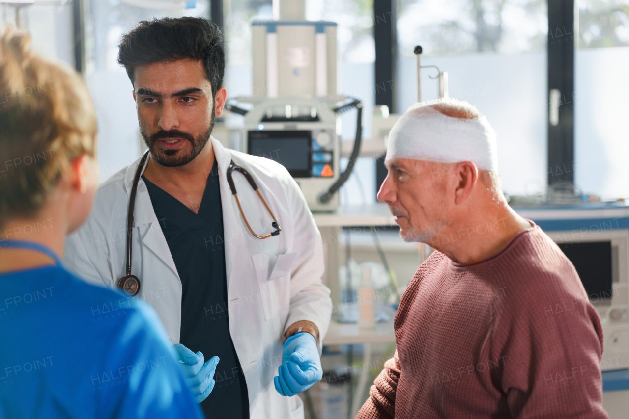 Young doctor and nurse treating of injured senior man.