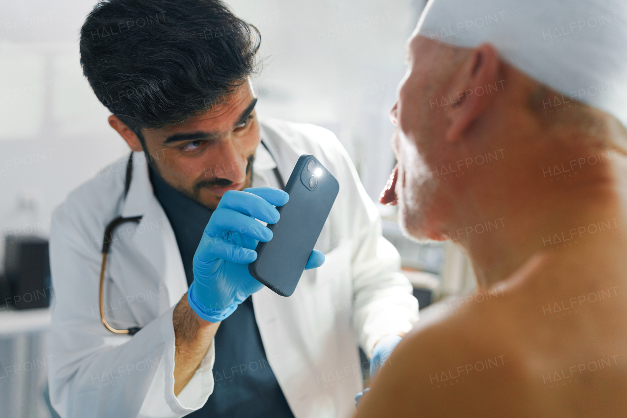 Doctor examining senior man with injured head.