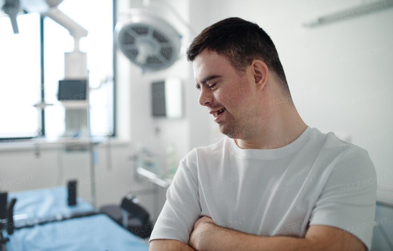 Young man with down syndome working in a hospital as helper, cleaner. Concept of integration people with disability into society.