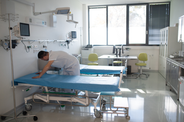 Young man with down syndome working in a hospital as helper, cleaner. Concpet of integration people with disability into society.