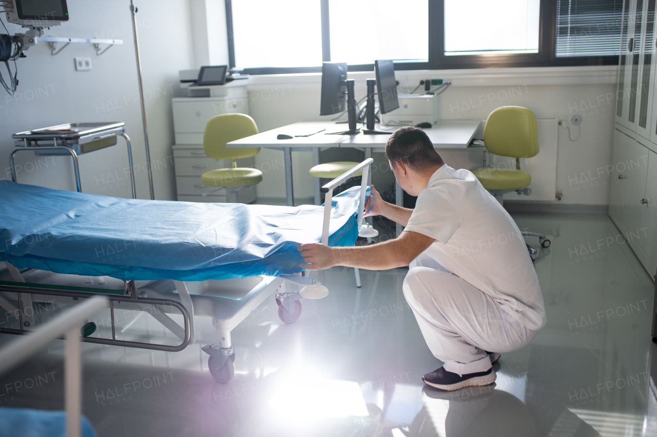 Young man with down syndome working in a hospital as helper, cleaner. Concpet of integration people with disability into society.