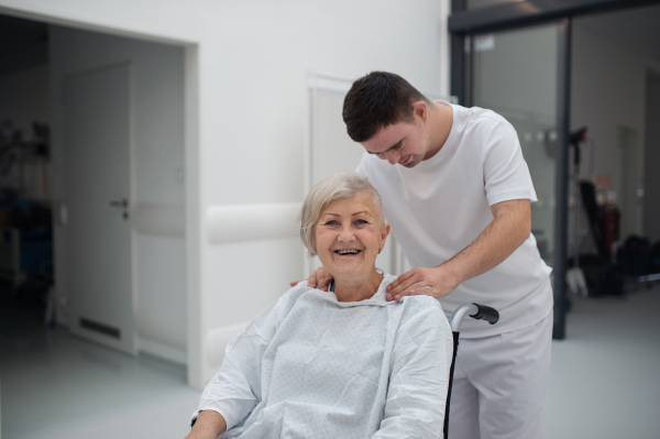 Young man with down syndome working in a hospital as a caregiver. Concpet of integration people with disability into society.