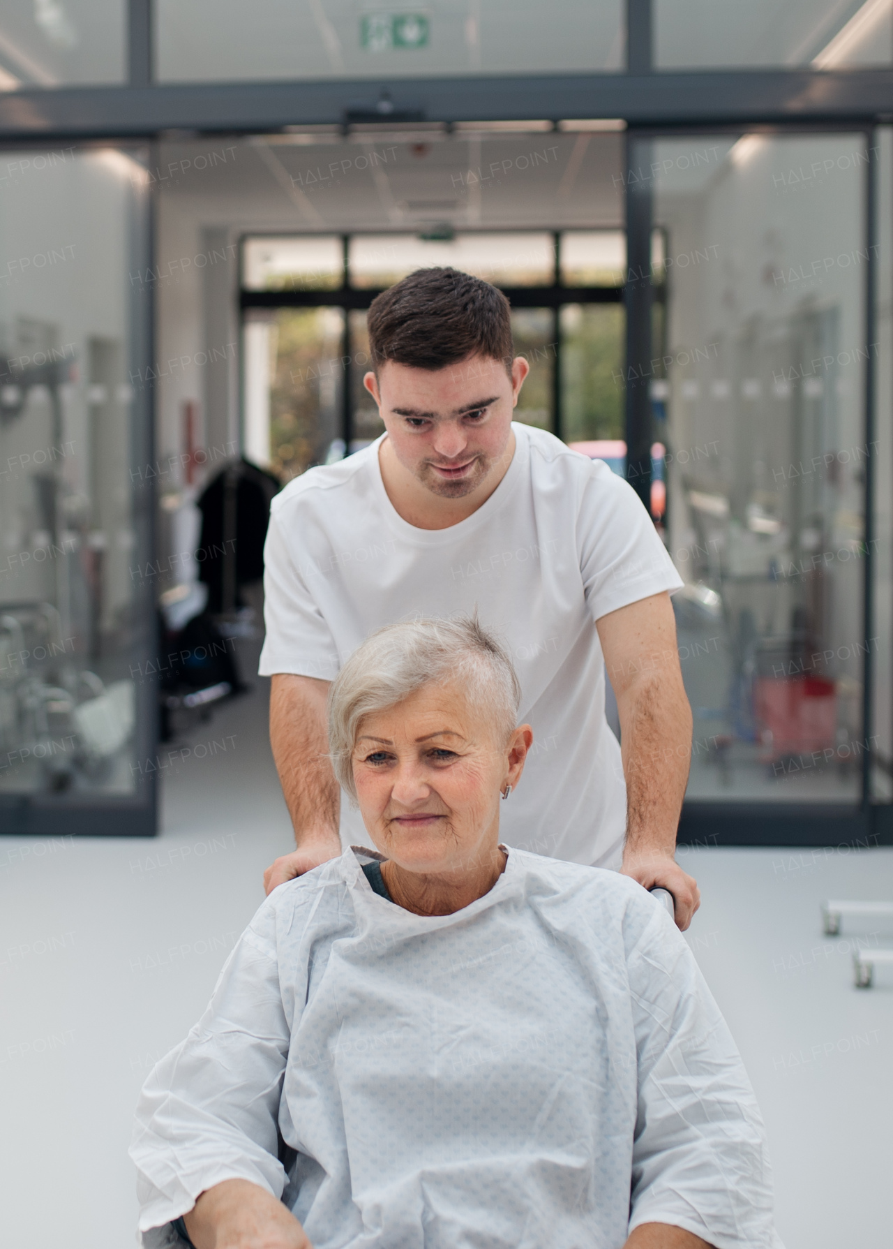 Young man with down syndome working in a hospital as a caregiver. Concpet of integration people with disability into society.