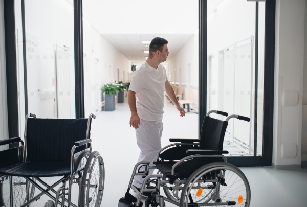 Young man with down syndome working in a hospital as a caregiver. Concpet of integration people with disability into society.