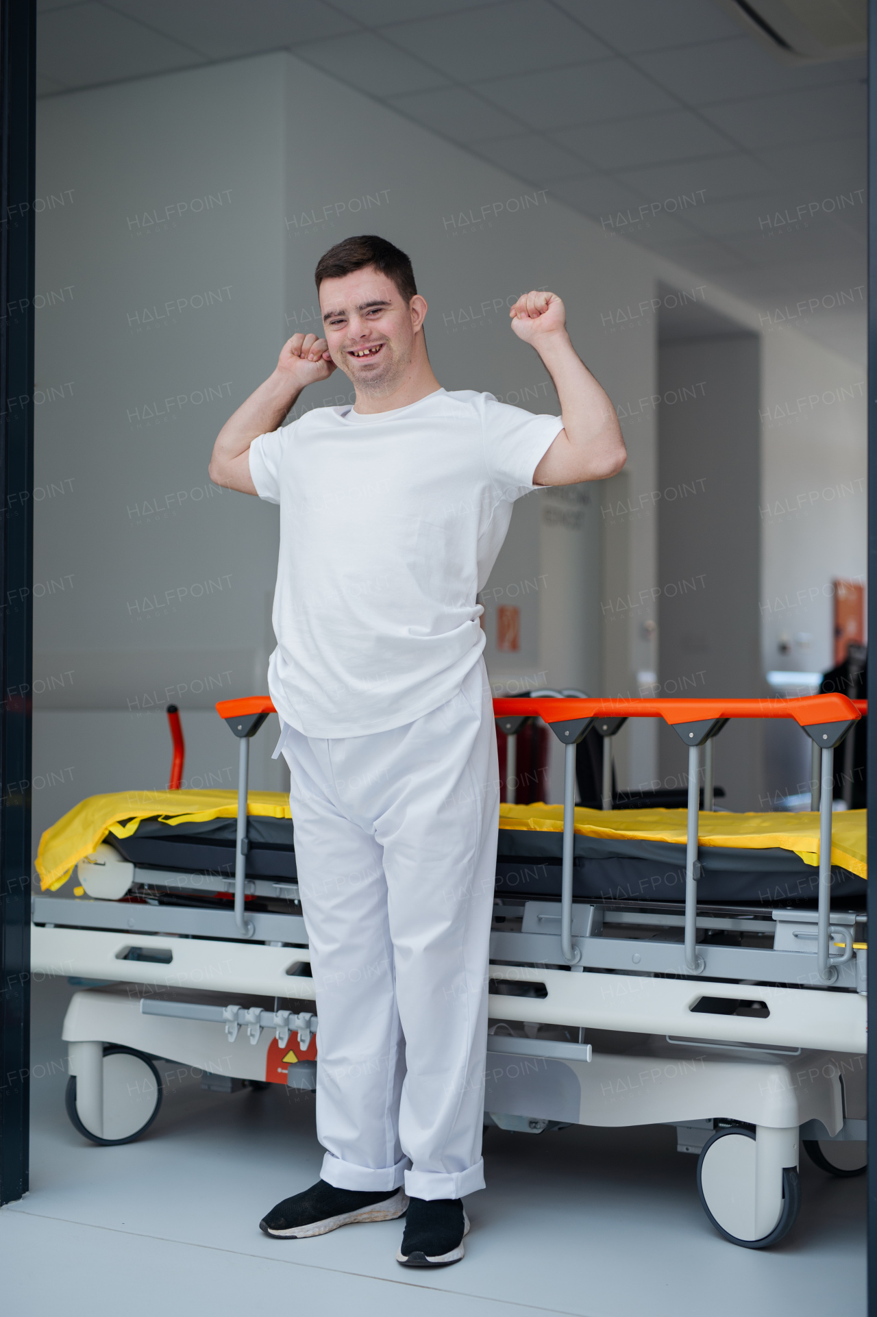 Young man with down syndome working in a hospital as a caregiver. Concpet of integration people with disability into society.