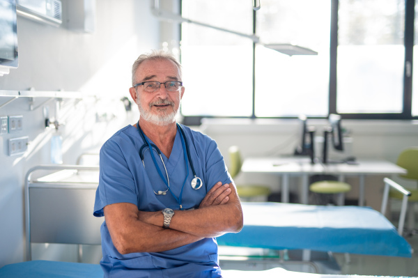 Portrait of elderly doctor in a hospital room.