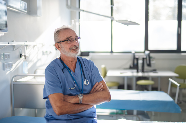 Portrait of elderly doctor in a hospital room.