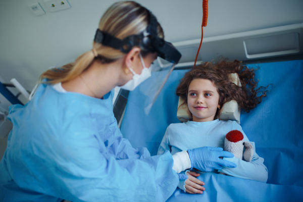 Friendly doctor taking care and playing with little patient.