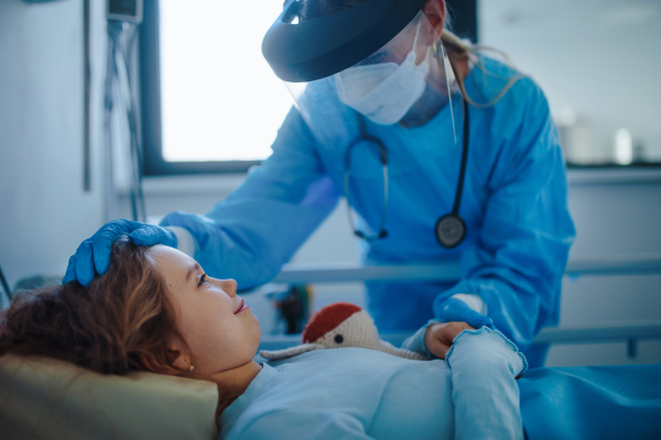 Friendly doctor taking care and playing with little patient.