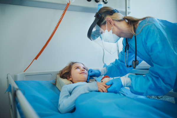 Friendly doctor taking care and playing with little patient.