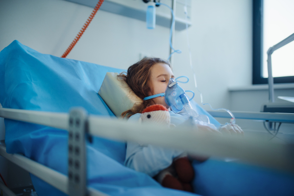 Close-up of girl with infection disease lying in hospital room.