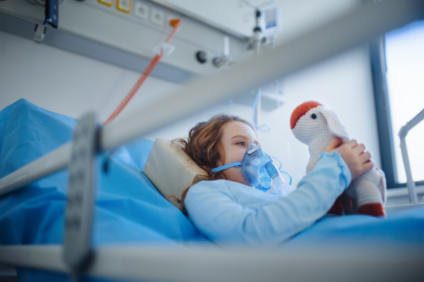 Close-up of girl with infection disease lying in hospital room.