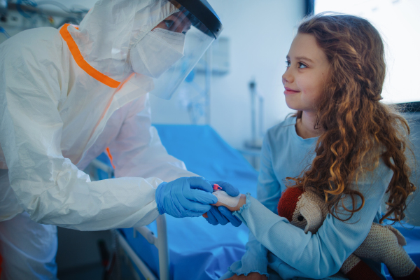 Friendly doctor taking care and playing with little patient.