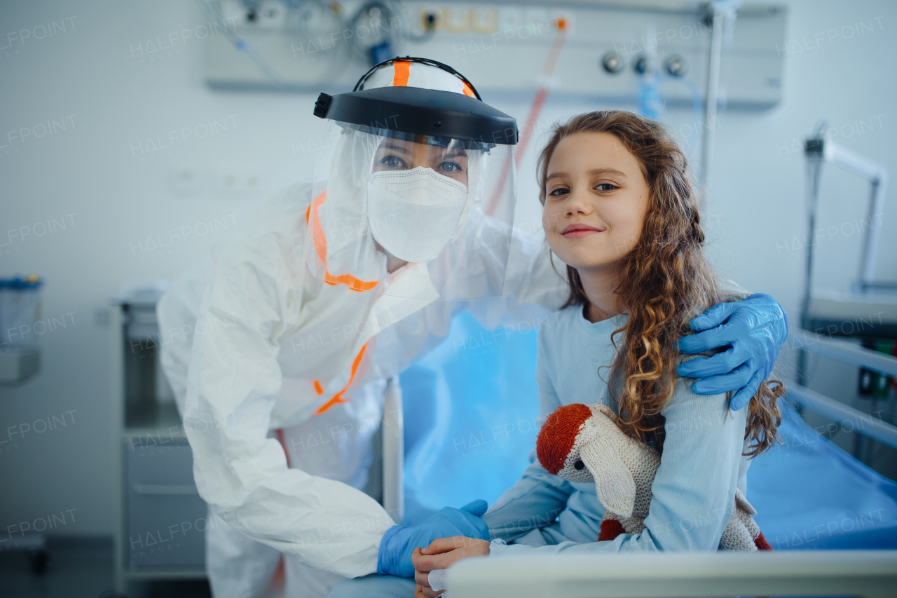 Portrait of healed child with doctor at isolation ward in a hospital.