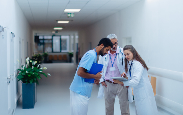 Team of doctors discussing something at a hospital corridor.