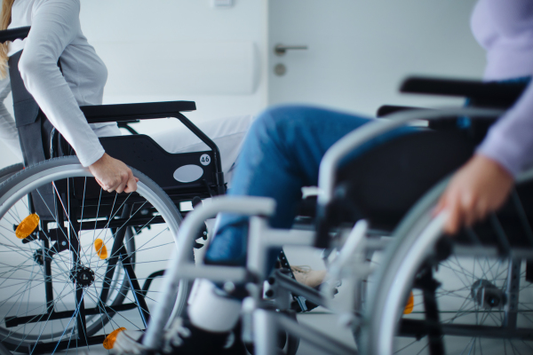 Close-up of young women at wheelchairs in a hospital.