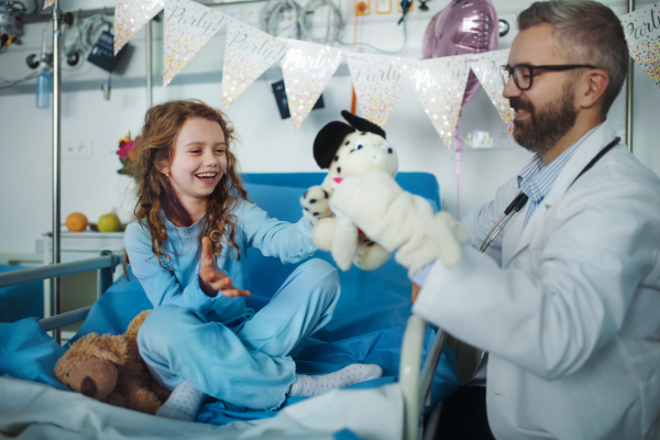 Friendly doctor taking care and playing with little patient.