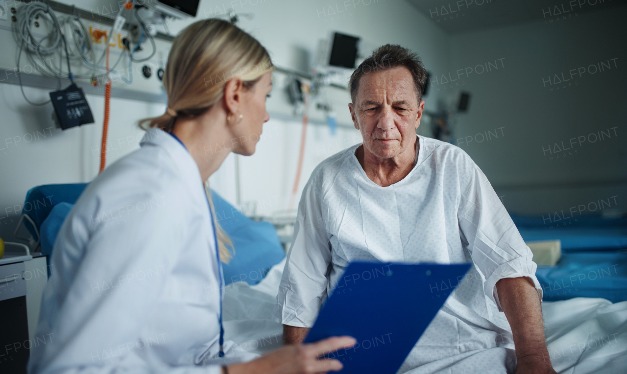 Young woman doctor explaining diagnosis to her patient in hospital room.