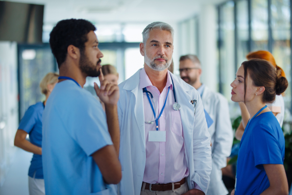 Team of doctors discussing something at a hospital corridor.